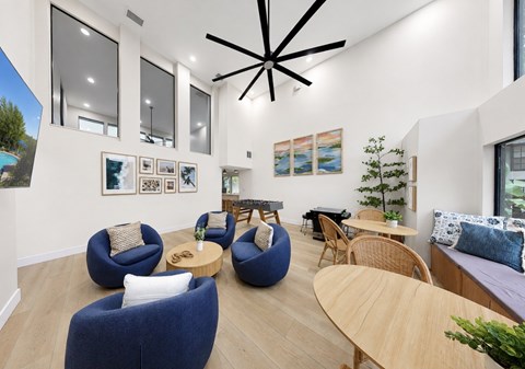 A modern living room with blue chairs and a wooden table.