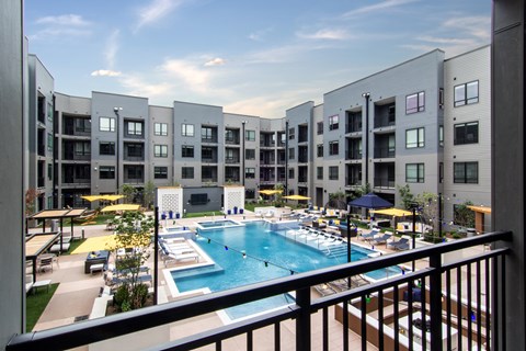 A large swimming pool is surrounded by apartment buildings.