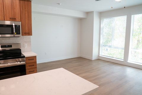 A kitchen with a white countertop and wooden cabinets.