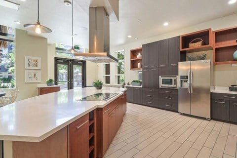 A modern kitchen with a large island and stainless steel appliances.