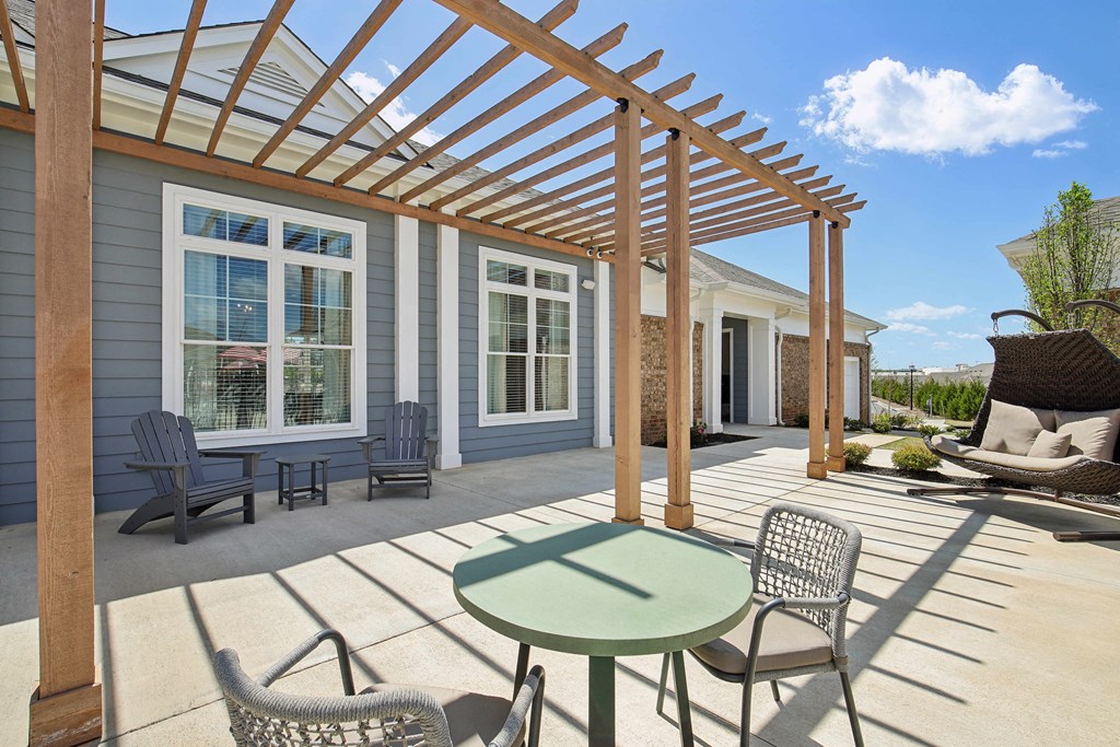 a patio with chairs and a table and a pergola
