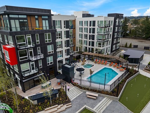 A modern apartment complex with a pool and a playground.