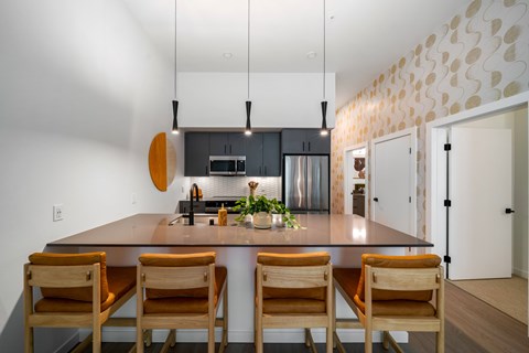 A modern kitchen with a wooden table and chairs.