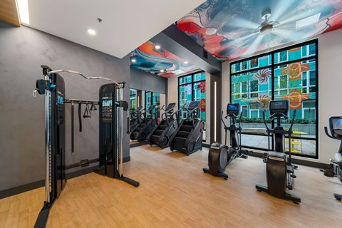 A gym with a variety of equipment including treadmills, stationary bikes, and weight machines.