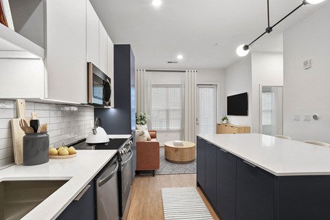 A modern kitchen with dark cabinets and a white countertop.