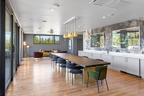A modern dining room with a long table and chairs.
