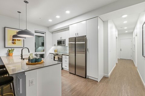 A modern kitchen with white cabinets and stainless steel appliances.