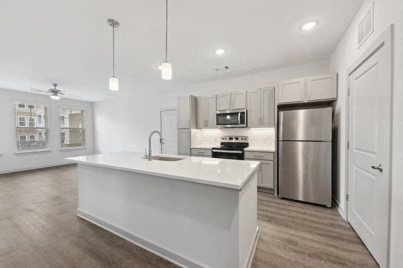 a kitchen with a large center island next to a stove top oven