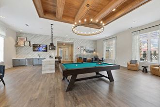 a spacious game room with a pool table and a flat screen tv