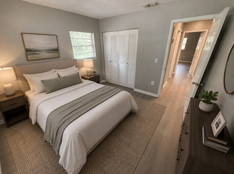 A bedroom with a large bed and a painting on the wall.
