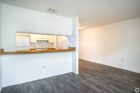 A kitchen with white walls and a wooden countertop.