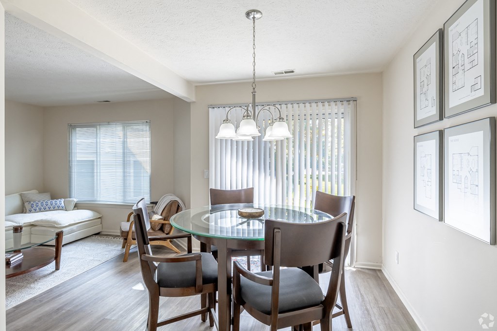 A dining room with a glass table and chairs.