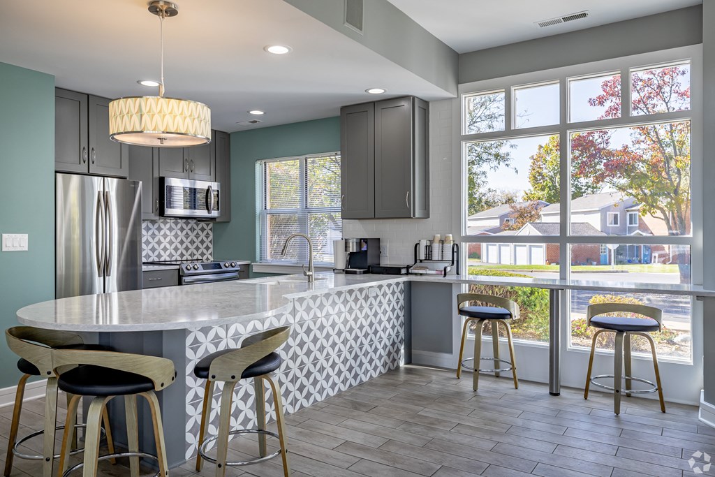 A kitchen with a large island and bar stools.