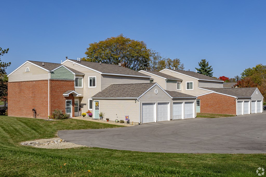 A large house with a driveway in front.