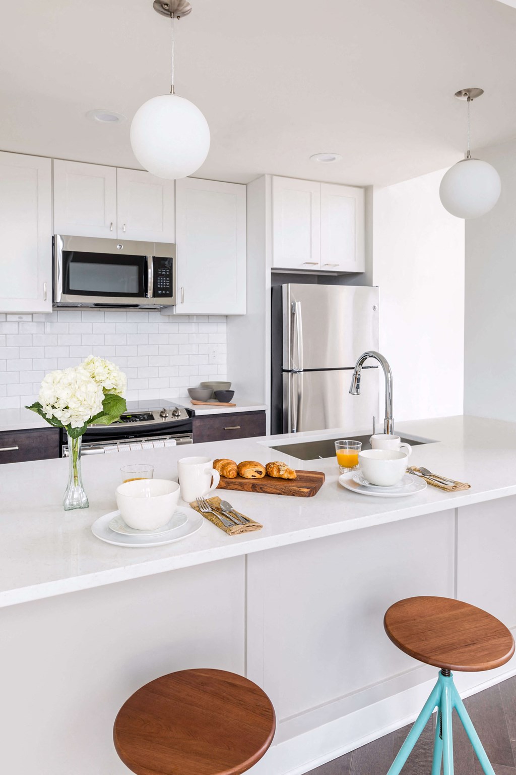 A kitchen with white cabinets and a white countertop with breakfast items on it at The Pennsylvanian Apartments, Pittsburgh, PA, 15222