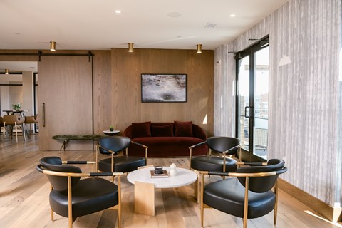 A modern living room with a red couch and black chairs.