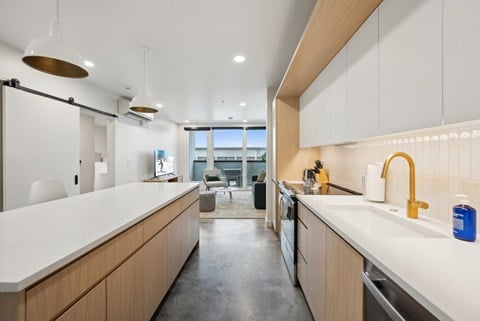 A modern kitchen with wooden cabinets and a white countertop.
