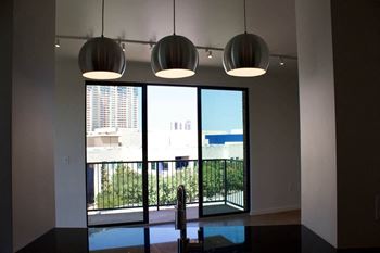 a living room with a large window and three hanging lights