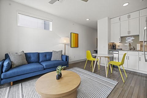 A living room with a blue couch and yellow chairs.
