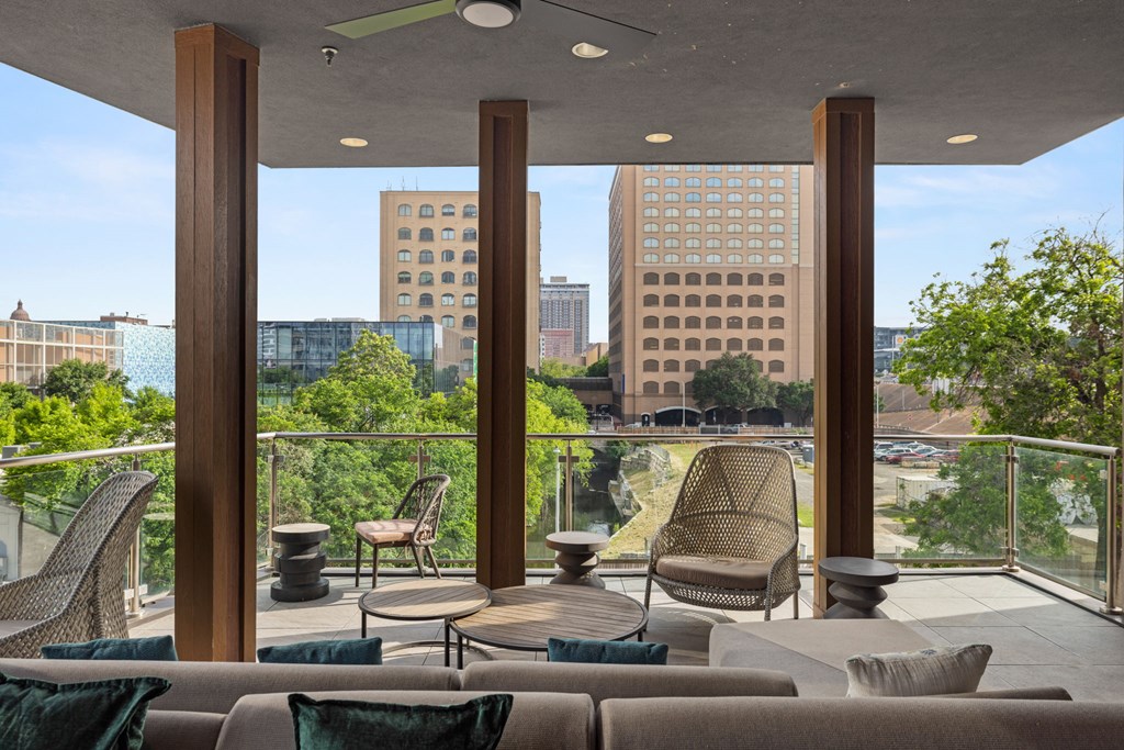 A patio with a couch and chairs overlooking a city.at Placemakr Downtown Austin, Texas, 78701