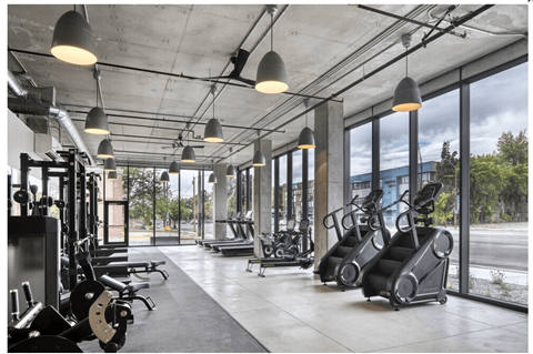 A gym with a variety of equipment including treadmills, weights, and exercise machines.