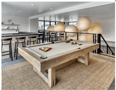 A pool table in a room with a bar area.
