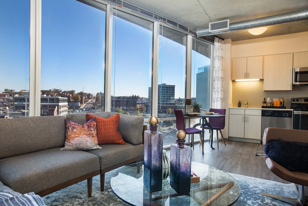 a living room with a couch and a glass coffee table in front of a window