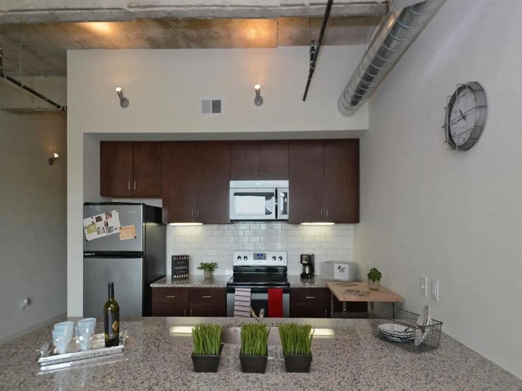 Kitchen with wooden closet and efficient appliances at 1221 Broadway Lofts, Texas, 78215