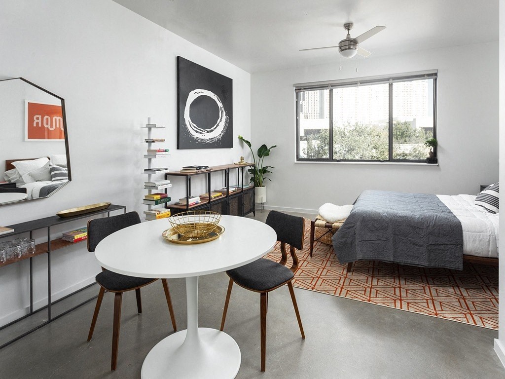 a living room with a bed and a white table and chairs