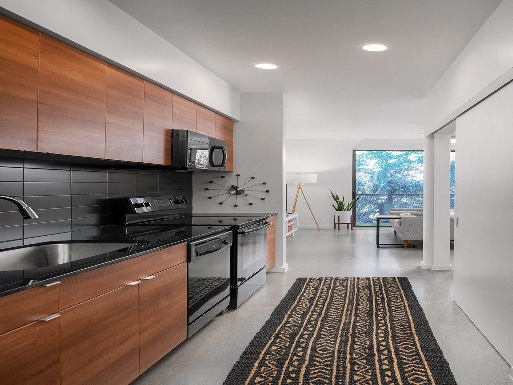 a kitchen with a black stove and a clock on the wall