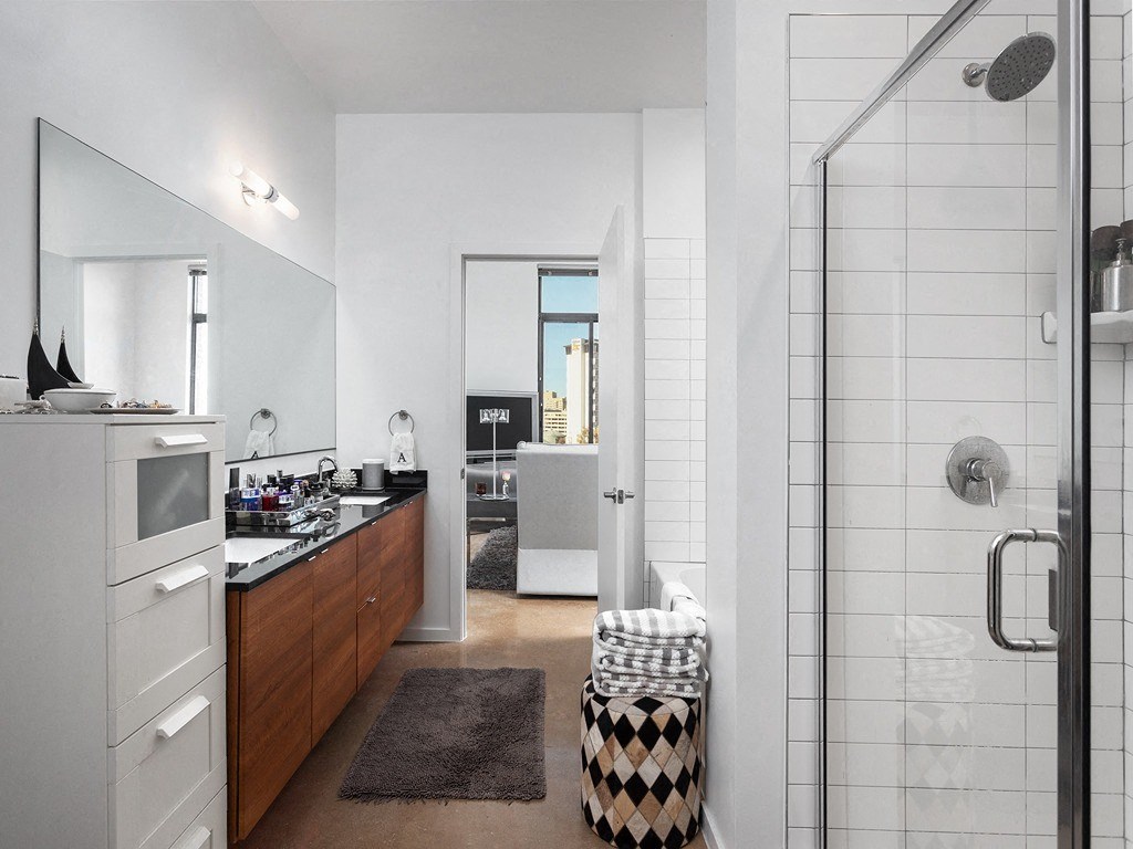 a bathroom with a shower and a sink and a mirror