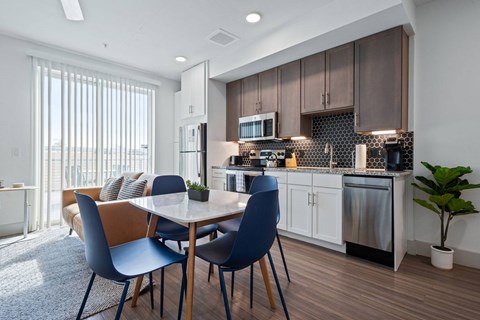A modern kitchen with a dining table and chairs.