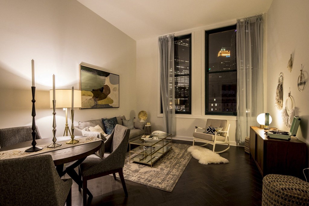 A well-lit living room with a dining table and chairs at The Pennsylvanian Apartments, Pittsburgh, PA