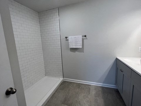 a bathroom with a shower and a sink and a towel