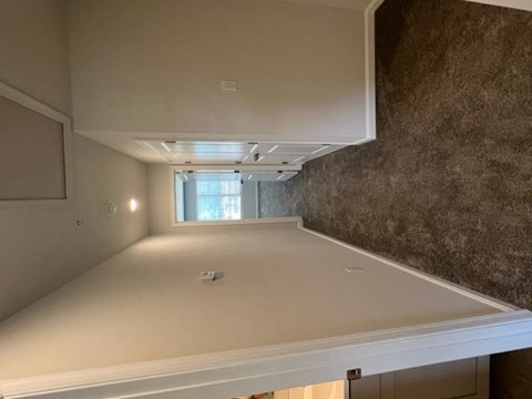 an empty kitchen with a counter top and a window
