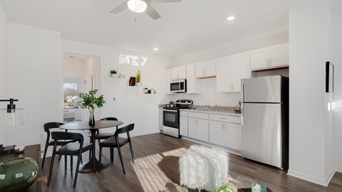 A modern kitchen with white cabinets and a black fridge.