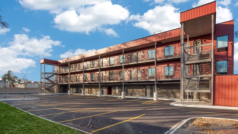 A large red building with a parking lot in front.