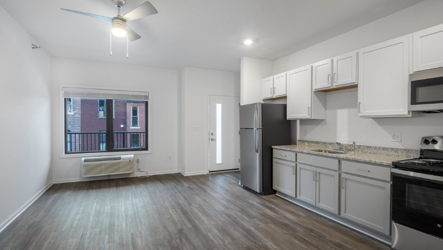 A kitchen with white cabinets and a black stove top oven.