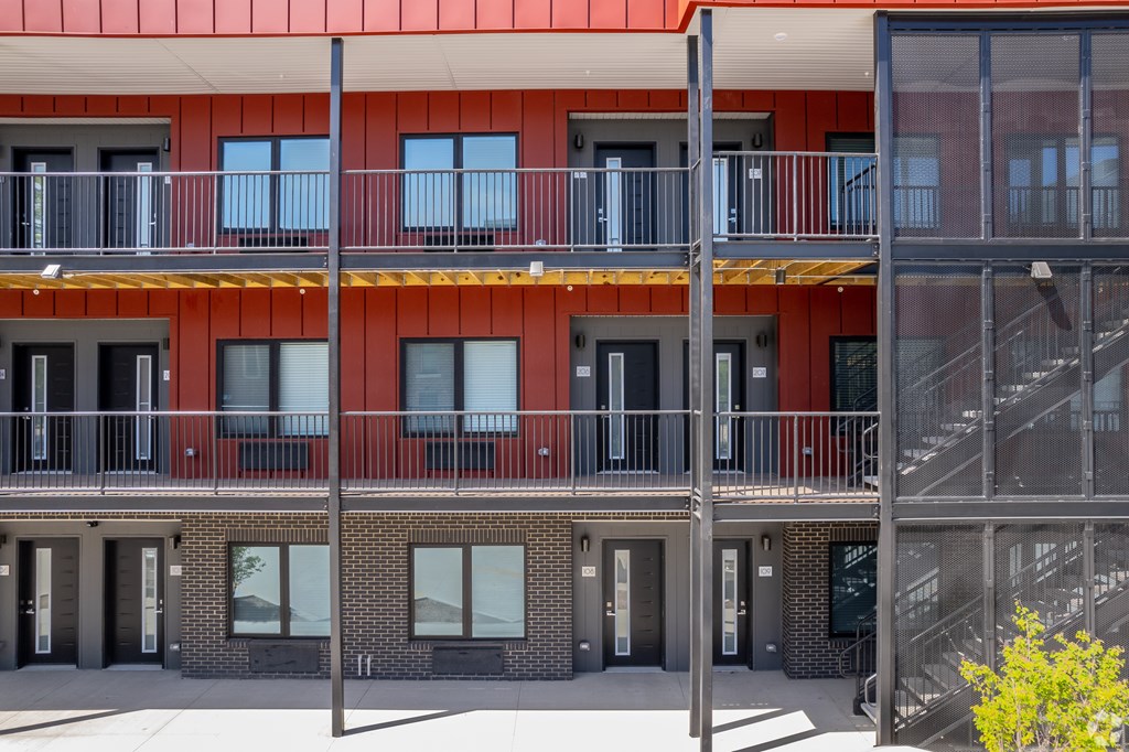 A modern building with a red roof and balconies.