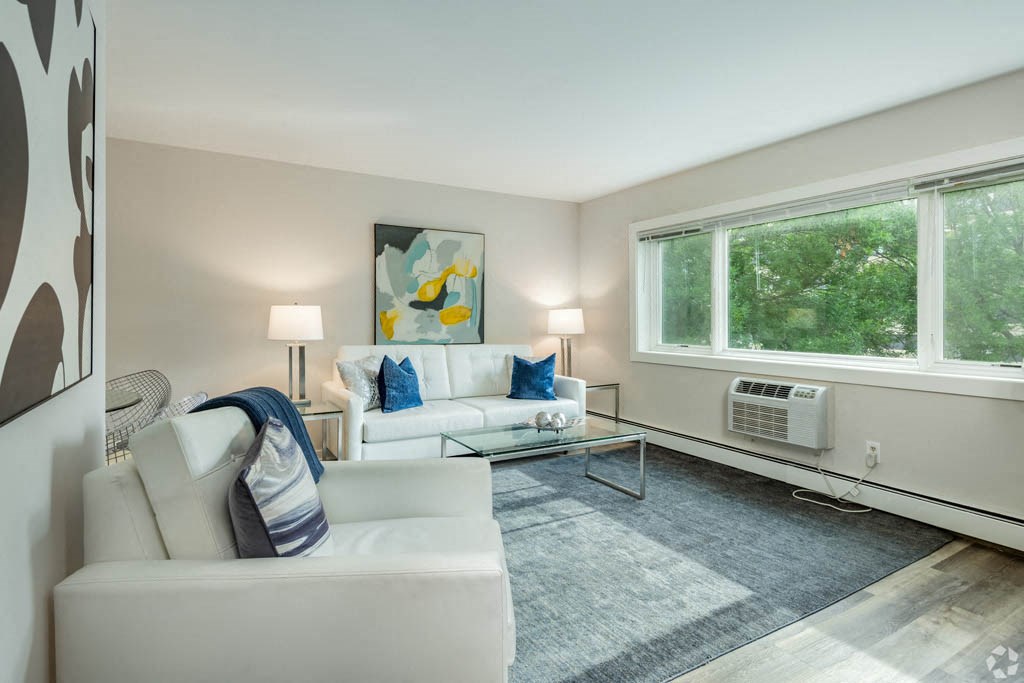 a living room with white furniture and a large window