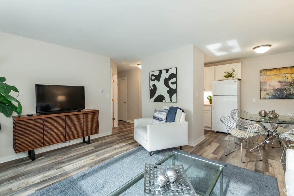 a living room with a tv and a table and chairs