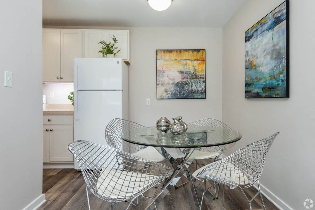 a dining room with a table and chairs and a refrigerator