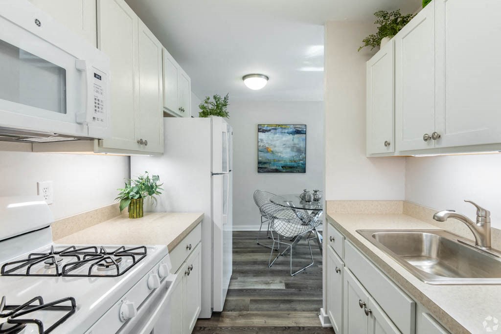 a kitchen with white cabinets and appliances and a sink
