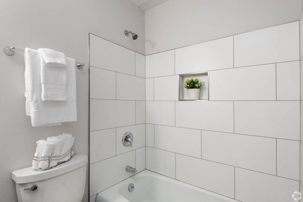 a white bathroom with a shower and a toilet