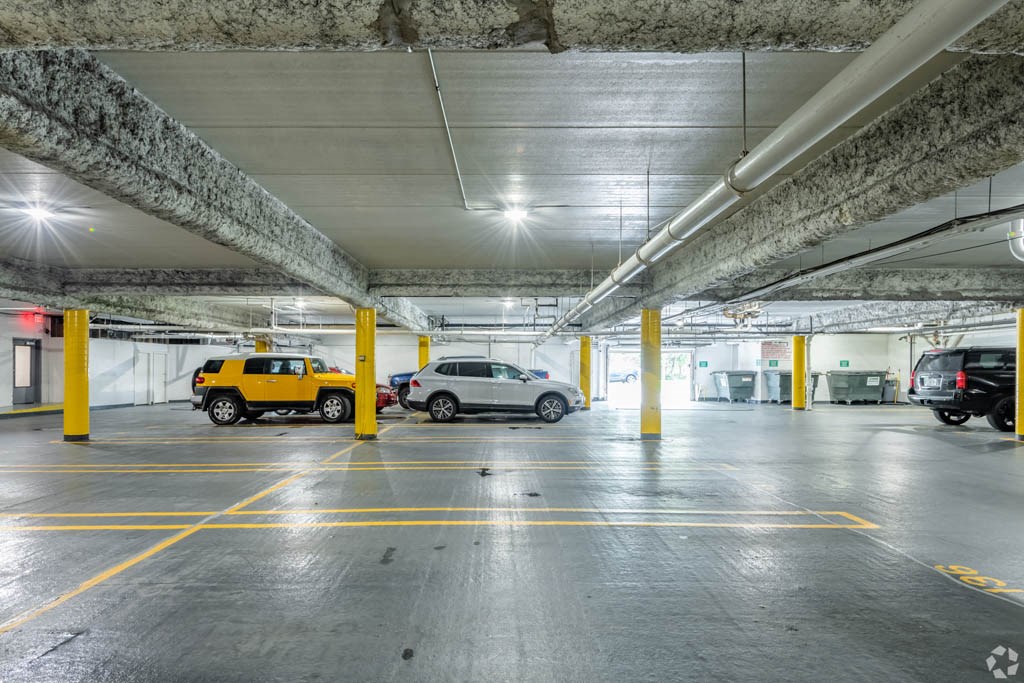 a parking garage with cars and a yellow truck