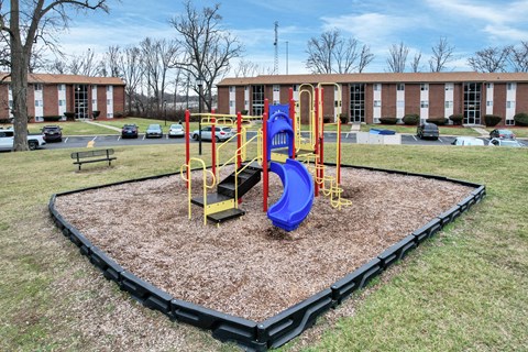 A playground with a blue slide and yellow poles.