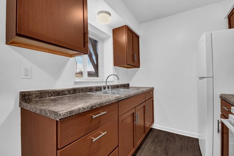 A kitchen with brown cabinets and a granite countertop.