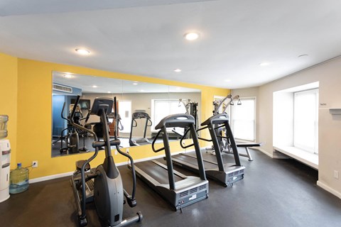 a room with a lot of exercise equipment and a large mirror