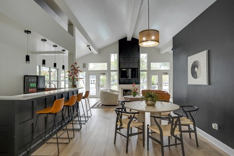 A modern dining room with a bar area and a large window.