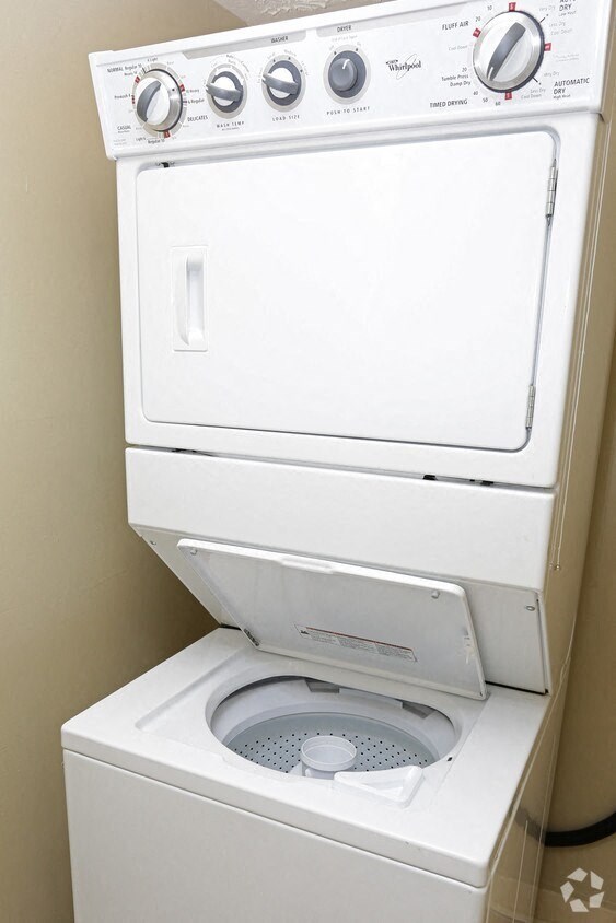 a washer and dryer in a bathroom with a toilet